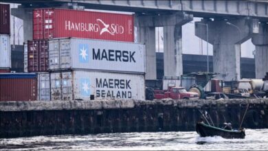 Maersk shipping containers stacked on a large cargo vessel.