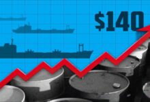 Multiple large oil tankers navigate a busy shipping lane in calm waters.