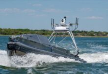 A US Navy unmanned surface vessel (USV) navigates blue waters.