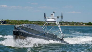 A US Navy unmanned surface vessel (USV) navigates blue waters.