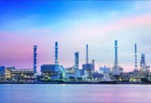 Modern ships and cranes at a bustling port, representing Singapore's maritime energy hub.