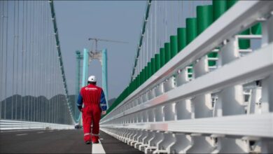 A large cargo ship in dry dock, likely receiving Hempel marine coatings.