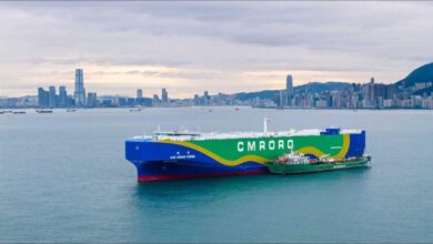 A large container ship undergoes green methanol bunkering in Hong Kong's busy port.