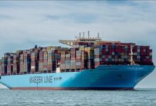A large Maersk container ship, MAERSK EINDHOVEN, sails on the sea.