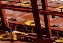 A Hapag-Lloyd container ship sails on the ocean, symbolizing global freight shipments.