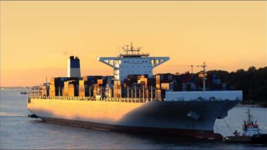 Large container ships load cargo at a bustling global port terminal.
