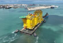 Boluda Towage tugboats escort a large offshore platform, representing maritime services.