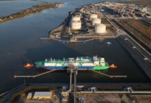 Aerial view of the Golden Pass LNG terminal showing large storage tanks and industrial facilities.