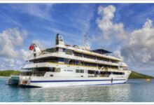 The Fiji Princess cruise ship aground on a reef near a tropical shore.