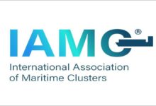 The IAMC logo features a world map graphic on a blue background.