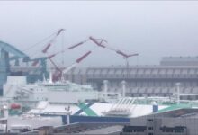 A large grey submarine docked at the HD Hyundai Heavy Industries shipyard in Ulsan.