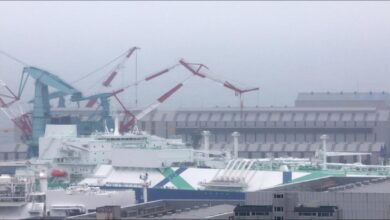 A large grey submarine docked at the HD Hyundai Heavy Industries shipyard in Ulsan.
