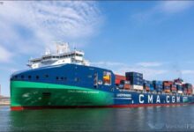 A CMA CGM container ship loads cargo at a bustling port.