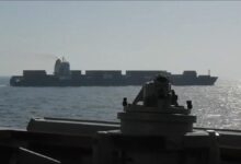 A large tanker ship sails on the ocean, symbolizing maritime trade and security.