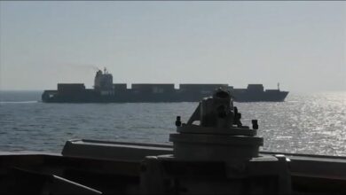 A large tanker ship sails on the ocean, symbolizing maritime trade and security.