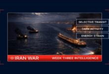 A large cargo containership fully loaded with shipping containers on the ocean.