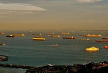 A large chemical tanker vessel docked in a busy port.