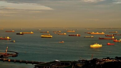 A large chemical tanker vessel docked in a busy port.