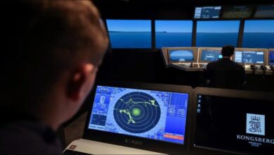 A detailed view of a Kongsberg K-Sim Navigation maritime simulator used for cadet training.