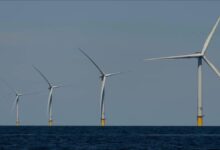 Offshore wind turbines stand tall at sea, symbolizing renewable energy.
