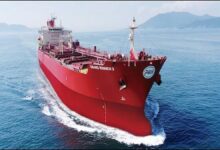 A large Very Large Crude Carrier (VLCC) oil tanker sails on the open sea.
