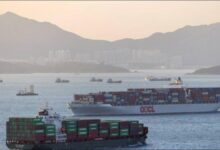 A large container ship with stacked containers sailing at sea.