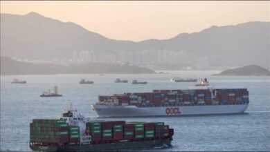 A large container ship with stacked containers sailing at sea.