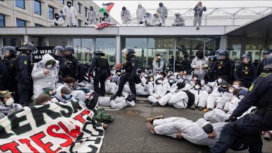 Protestors with signs demonstrating outside the Maersk headquarters building.