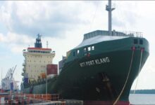 MTT Shipping container vessel at Port Klang with cranes loading cargo.