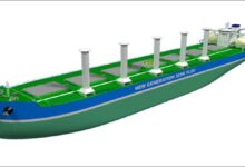 A large cargo ship, possibly an ore carrier, sails on the open ocean.