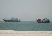 A large cargo ship transits the Strait of Hormuz, a vital maritime chokepoint.