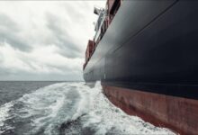 Large cargo ship hull, partially submerged, featuring advanced fouling control coatings for efficiency.