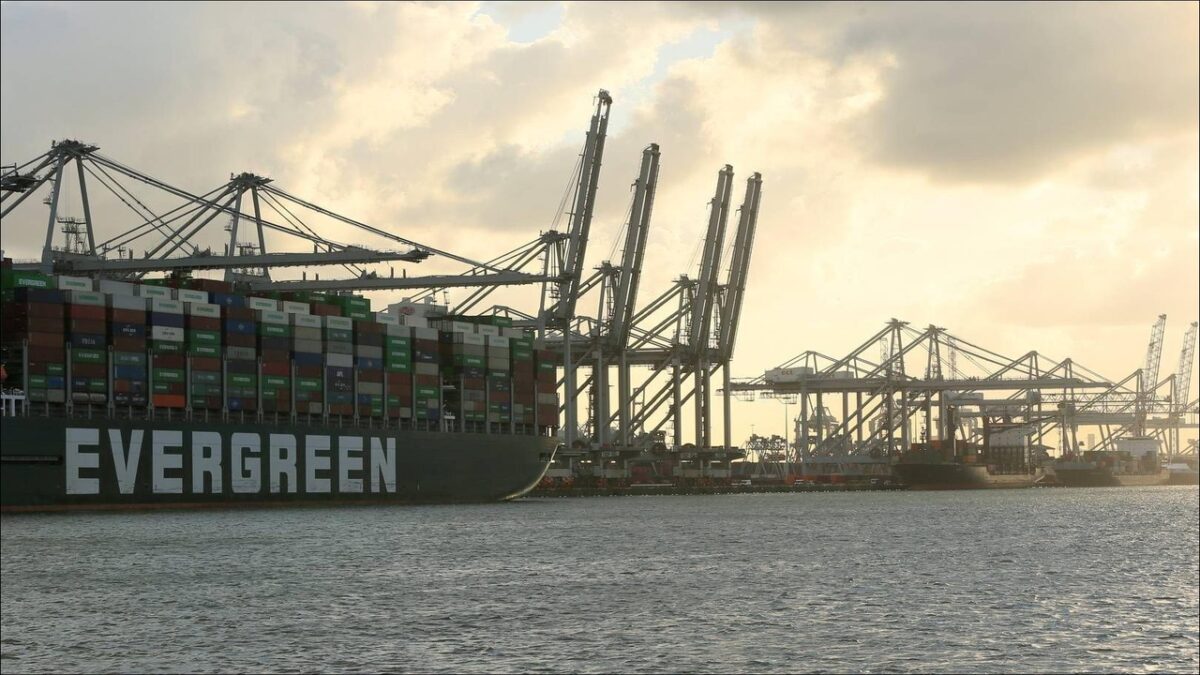 A large container ship sails a busy waterway, connecting to the Port of Rotterdam.
