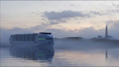 A modern electric battery-powered container vessel sailing on calm water.