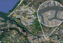 A large ship is docked at a bustling port terminal with fuel tanks, representing marine biofuel operations.