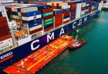 A CMA CGM container ship is docked at port with industrial equipment for bunkering.