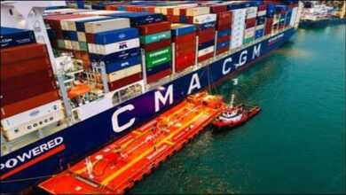A CMA CGM container ship is docked at port with industrial equipment for bunkering.