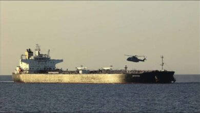 Royal Navy vessel escorts a detained tanker at sea during an enforcement operation.