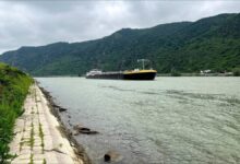 A cargo ship navigates extremely low water levels on the Rhine River.
