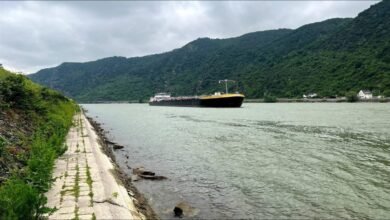 A cargo ship navigates extremely low water levels on the Rhine River.