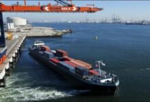 A large vessel receiving marine fuel from a bunker barge in the busy port of Rotterdam.
