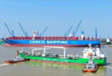A large COSCO container ship receives methanol fuel via ship-to-ship bunkering from a smaller tanker.
