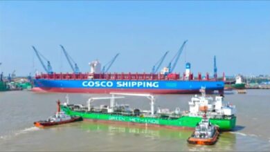 A large COSCO container ship receives methanol fuel via ship-to-ship bunkering from a smaller tanker.