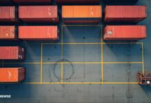 A large container ship packed with cargo containers sails, illustrating global supply chain logistics.
