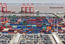 A large container ship full of colorful shipping containers at sea.