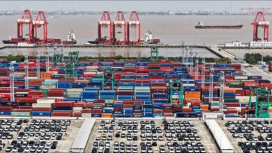 A large container ship full of colorful shipping containers at sea.