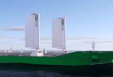 An Ultramax bulk carrier with large OceanWings rigid sails deployed at sea.