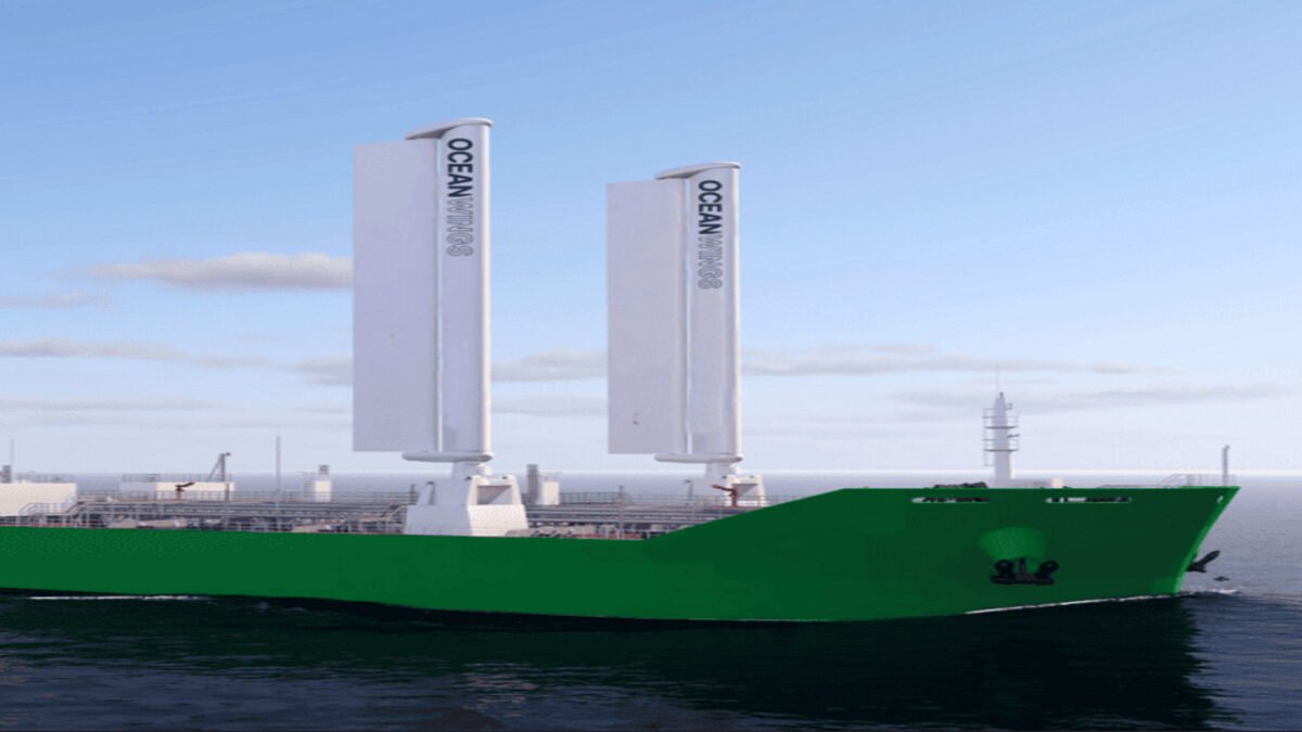 An Ultramax bulk carrier with large OceanWings rigid sails deployed at sea.