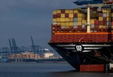 A massive MSC container ship sails on a waterway.