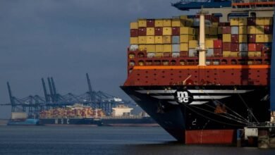 A massive MSC container ship sails on a waterway.